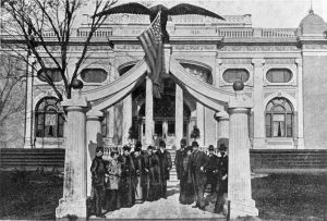 Individuals under the Eagle Gate monument replica outside the Utah Building at the Columbian Exposition in Chicago in 1893.