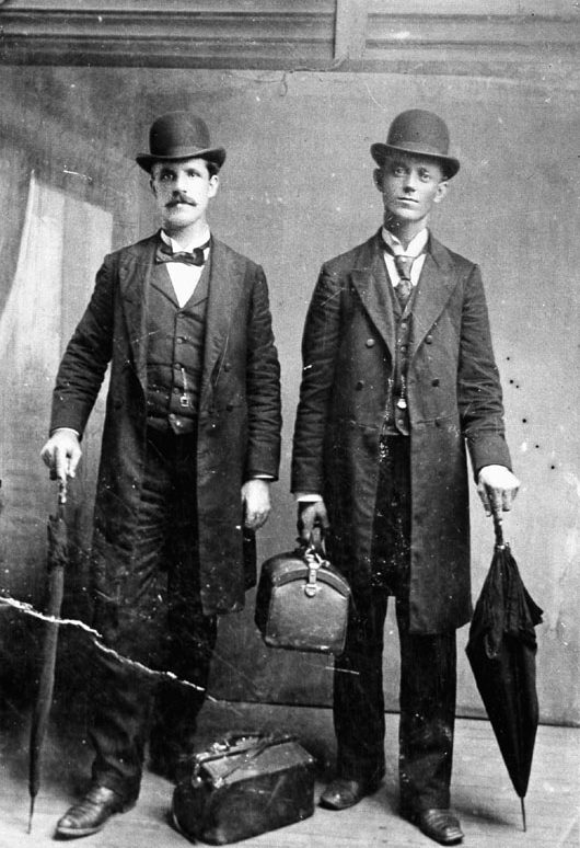 Latter-day Saint missionaries were sent all over the world to proselytize, this pair in Mississippi. A. T. Rose and G. M. Fryer, pictured here, are wearing Prince Albert coats and derbies with umbrellas and satchels, considered standard missionary attire.
